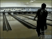 a man is walking down a bowling alley with a 4gifs.com watermark in the corner