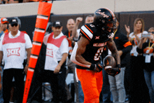 a football player for the oklahoma cowboys is running with a ball