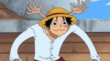 a cartoon character wearing a straw hat and a white shirt is standing next to a rock .