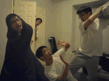 three young men are having a pillow fight in a room