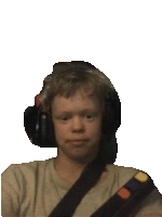 a young boy wearing headphones and a belt looks at the camera