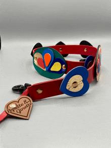 a red leather belt with a heart shaped tag that says repette & ginette