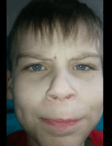 a close up of a young boy 's face with blue eyes