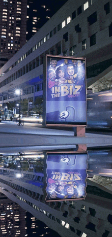 a billboard that says ' in biz ' on it in front of a building