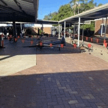 a brick courtyard with tables and chairs under a canopy