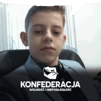 a boy in a suit is sitting in front of a konfederacja logo