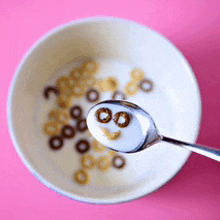 a bowl of cereal with a spoon in it that looks like a face