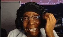 a woman wearing glasses and a headband is making a funny face