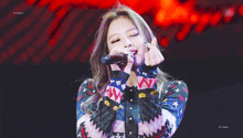 a girl is singing into a microphone and making a heart with her fingers