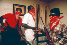 three men wearing red bandanas are holding guns