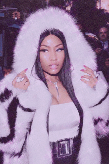 a woman wearing a fur coat with a hood