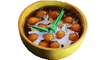 a bowl of soup with balls in it and a green leaf