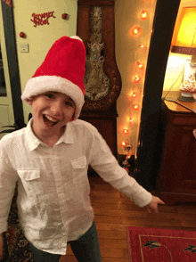 a boy wearing a santa hat is pointing at something