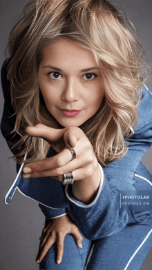 a woman with a ring on her finger is pointing