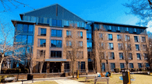 a large brick building with lots of windows sits in the middle of a grassy field