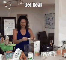 a woman in a blue tank top is making a smoothie with a sign that says simply amazing in the background