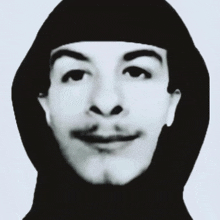 a black and white photo of a man with a hood on