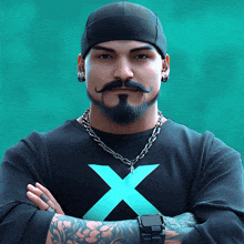 a man with a beard and mustache is wearing a black shirt with a blue x on it