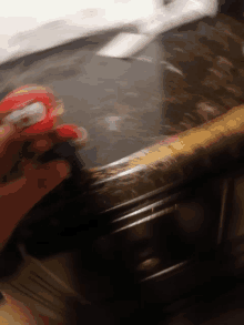 a blurred image of a person holding a toy mario