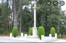 a cross in the middle of a forest with the letters cc on it