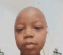 a close up of a child 's face with a bald head and headphones on .