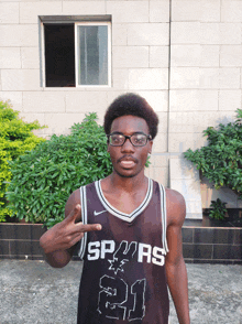 a man wearing glasses and a jersey that says spurs 21