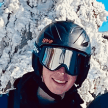 a man wearing a spy helmet and goggles smiles for the camera