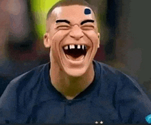 a man with a smiley face on his forehead is laughing .