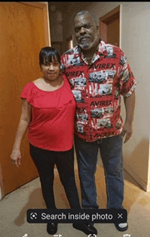 a man in an avirex shirt is standing next to a woman in a red top