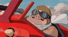 a pig is sitting in the cockpit of a red airplane .