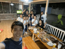 a group of people gathered around a table with food