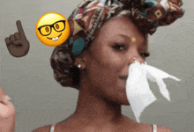 a woman wearing glasses and a head scarf is blowing her nose