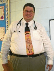 a man with a stethoscope around his neck is wearing a tie with a picture of a woman on it