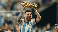 a soccer player is holding a trophy in his hand .