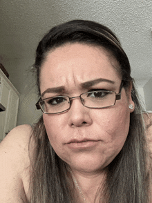 a woman wearing glasses makes a funny face