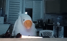 a stuffed duck with an orange beak is sitting on a table