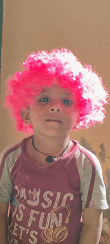 a young boy wearing a pink wig is wearing a shirt that says music is fun