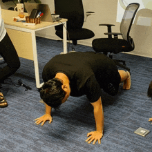 a man doing push ups in front of a desk with a coffee mug that says ' caffe latte ' on it