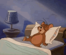 a cartoon mouse is laying on a bed with a pillow and smiling .