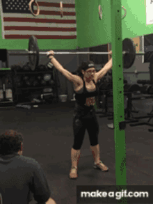 a woman is lifting a barbell in a gym while wearing a headband that says " because fuck you "