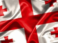 a close up of a red and white flag with a cross on it waving in the wind .