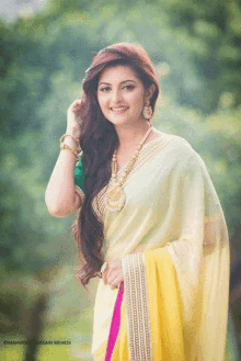 a woman wearing a yellow and white saree with mahmood nussain mehendi written on the bottom