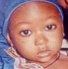 a close up of a baby wearing a blue headband