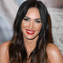 a woman with long hair and red lipstick smiles for the camera