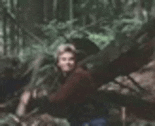 a blurry picture of a man standing in the woods .