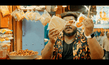 a man wearing sunglasses is holding a bag of food in front of his eyes