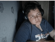 a young boy wearing headphones and a shirt that says 50