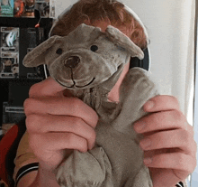 a person holding a stuffed animal in front of their face