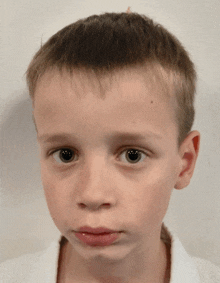 a close up of a young boy 's face with a serious look on his face