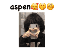 a person making a heart shape with their hands and the word aspen behind them